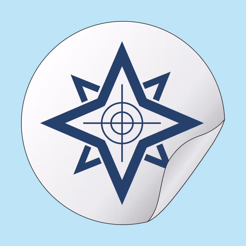 Round beige sticker with a dark blue star-shaped compass and target symbol in the center, peeling slightly at the edge.