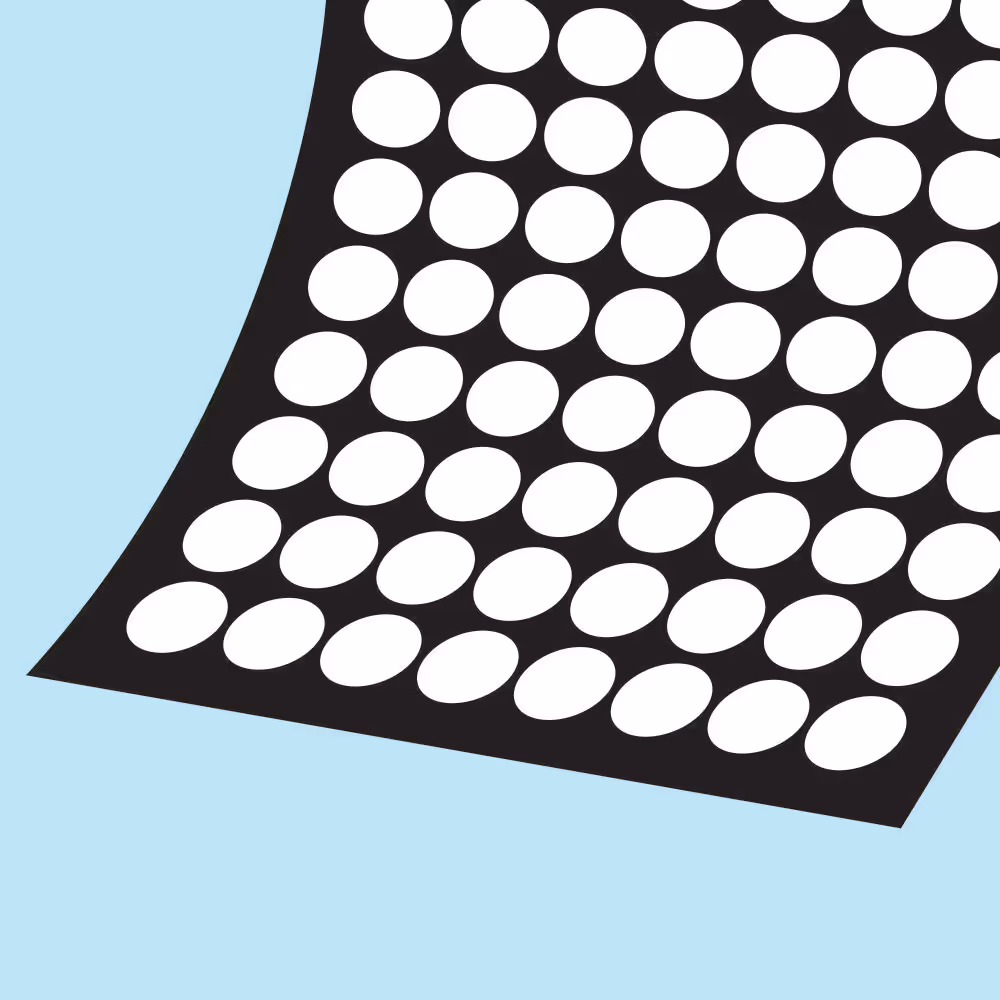 Close-up of a black sheet with evenly spaced white oval holes on a light blue background.